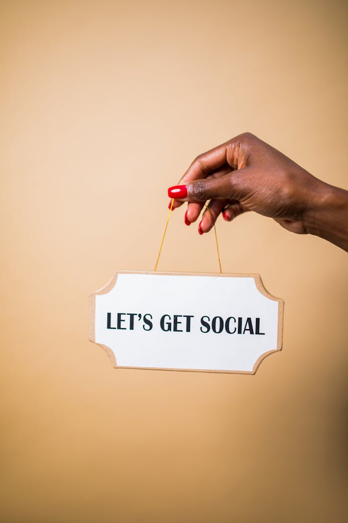A hand holding a u0022Let's Get Socialu0022 sign, ideal for marketing and social media themes.